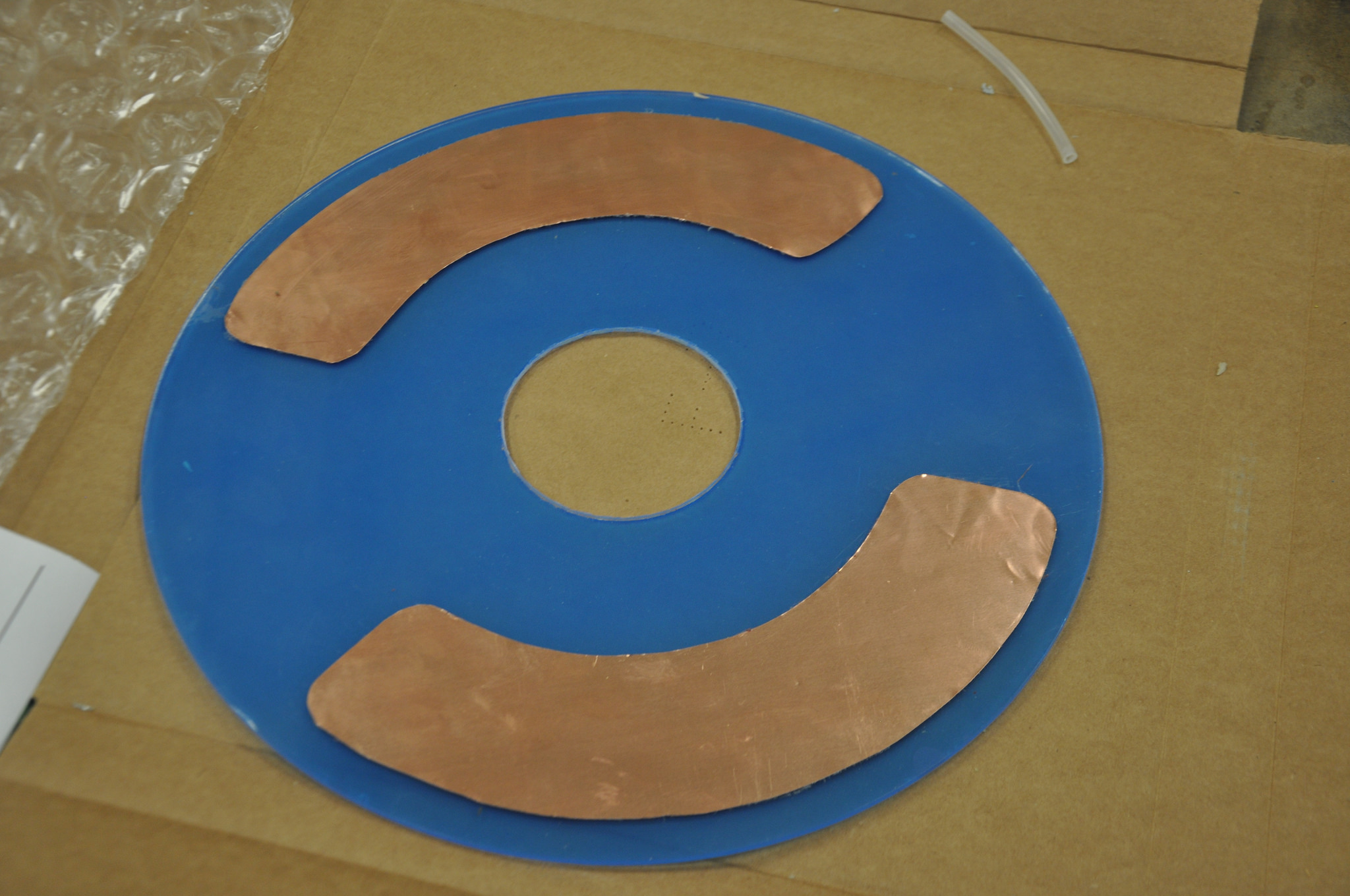 Plastic disk with glued on copper shim